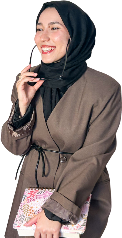 Meryem Sevim, elinde defter ve gözlükle gülümserken
